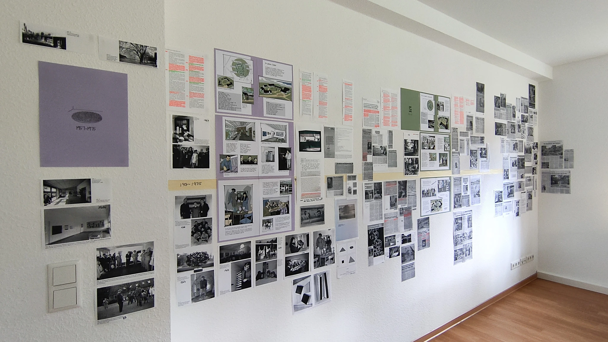Foto der Wände im Projektbüro mit den neuen Buchseiten und Recherchemateria