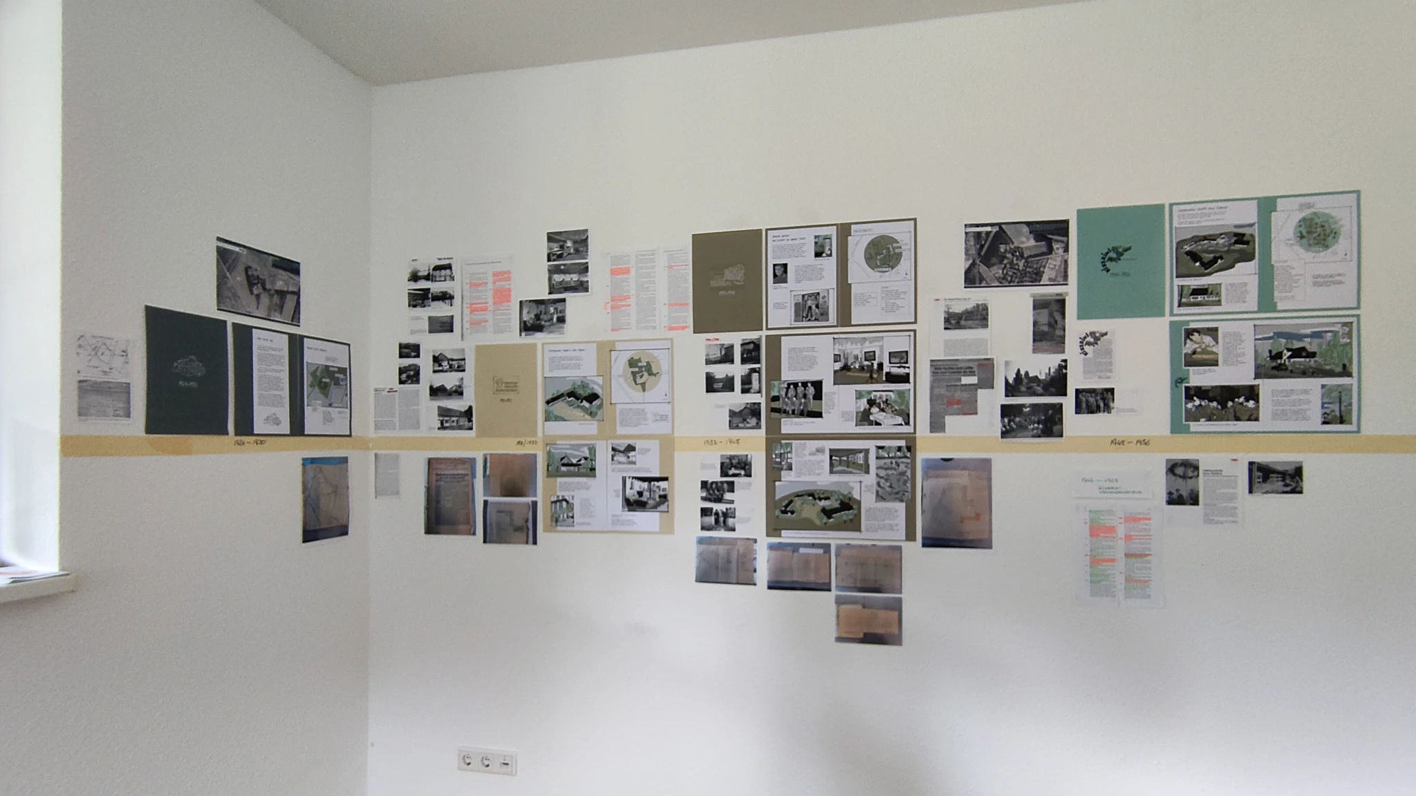 Foto der Wände im Projektbüro mit den neuen Buchseiten und Recherchemateria